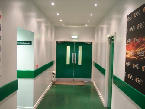 Stadium corridor with green dado rails and doors