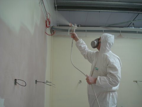 Spray coating walls in an industrial unit